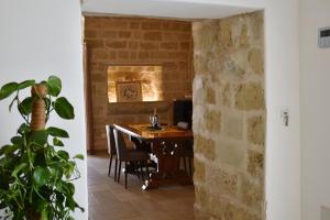 a dining room with a table and a brick wall at Suite Palazzo Palmieri in Martignano +23 photos