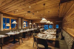 ein Restaurant mit Holzwänden, Tischen und Stühlen in der Unterkunft Genusshotel Vermala Montafon in Sankt Gallenkirch