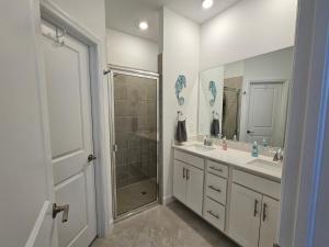 ein Bad mit 2 Waschbecken, einer Dusche und einem Spiegel in der Unterkunft Close to Englewood and Boca Grande beach, monthly New Vacation Villa in Englewood