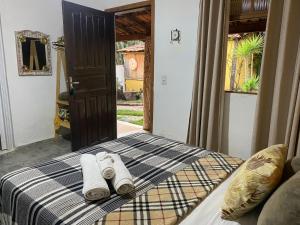 a bedroom with a bed with two rolled towels on it at Pousada Princesa da Serra in Serra do Cipo
