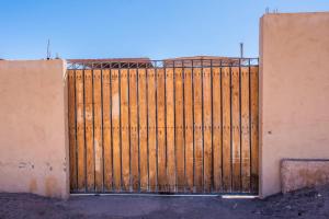 a wooden gate in the side of a building at Atacama Cottage in San Pedro de Atacama