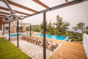 a patio with chairs and a swimming pool at ALLURE Luxury Villa One Skiathos in Skiathos