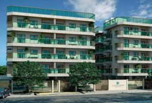a large apartment building with trees in front of it at Ocean garden in Cabo Frio