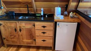 a small kitchen with a sink and a refrigerator at Chalés Roma in Santo Antônio do Pinhal +6 photos