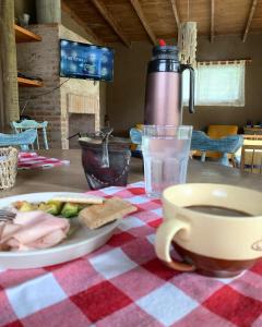 a table with a plate of food and a cup of coffee at Casa de Mar y Barro in Maldonado