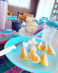 a plate with peeled oranges on a table with a knife at Casa de Mar y Barro in Maldonado +22 photos
