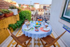een tafel met een blauw tafelkleed op een balkon bij Adore Portugal Coimbra Guest House in Coimbra +54 foto's