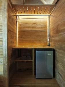 a room with a wooden wall with a desk and a television at Villa Scandinavia in Rincón