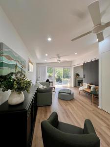 ein großes Wohnzimmer mit einem Sofa und Stühlen in der Unterkunft Cottage Hill Creek near the beach and bush in Macmasters Beach