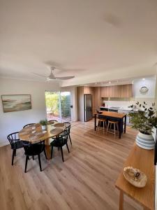 ein offenes Wohnzimmer mit einem Tisch und Stühlen in der Unterkunft Cottage Hill Creek near the beach and bush in Macmasters Beach