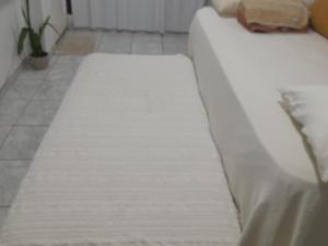 波萨达斯Pequeño Monoambiente Posadas centro的白色的床和白色的毯子
