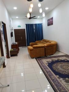 a living room with a brown couch in a room at D'tasek Homestay Gua Musang in Gua Musang
