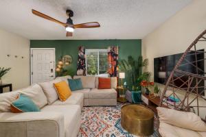 ein Wohnzimmer mit einer Couch und einem Deckenventilator in der Unterkunft Havana Hideaway 3BR Home with Private Pool and Dedicated Office in St. Augustine