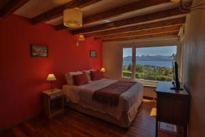 Un dormitorio con una cama grande y una ventana grande. en Ventanas Al Lago, en San Carlos de Bariloche