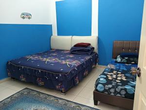 two beds in a room with blue walls at D'tasek Homestay Gua Musang in Gua Musang