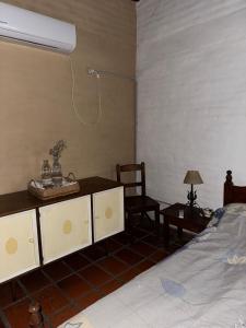 ein Schlafzimmer mit einem Bett, einem Schreibtisch und einem Stuhl in der Unterkunft El colibrí in Concordia