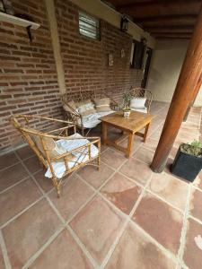 eine Terrasse mit 2 Betten, einem Tisch und einer Ziegelwand in der Unterkunft El colibrí in Concordia