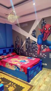 une chambre avec une fresque murale représentant un homme d'araignée dans l'établissement فيلا السعادة, au Caire