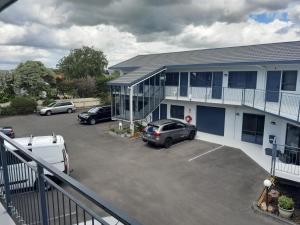 un'auto parcheggiata in un parcheggio di fronte a un edificio di A'Abode Motor Lodge a Palmerston North
