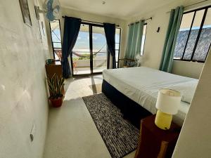 a bedroom with a bed and a large window at Stella Mar Oceanfront Hotel in Popoyo