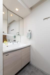 une salle de bain avec un lavabo et un miroir dans l'établissement Namba 2 bedroom apartment, 1 min to Nippombashi, à Osaka
