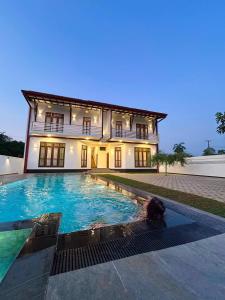 a house with a swimming pool in front of it at Villa Elegant Oasis in Horana