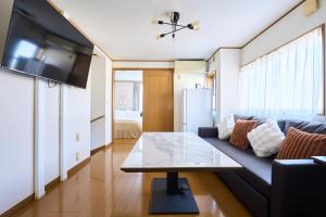 una sala de estar con un sofá y una mesa en JR ChuoLine Aasagaya station 5min,Shinjuku 8min Max15pp 2WC, en Tokio