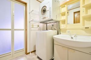 Un baño con lavabo y lavadora. en JR ChuoLine Aasagaya station 5min,Shinjuku 8min Max15pp 2WC, en Tokio