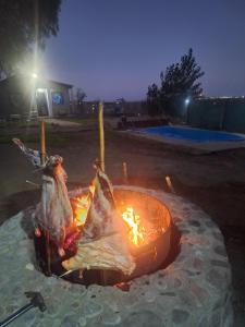 Cabaña la Morocha في سيوداد لوجان دي كويو: حفرة نار في ساحة في الليل +صورتان