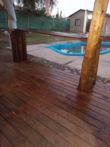 a person standing on a wooden deck next to a pool at Cabaña la Morocha in Ciudad Lujan de Cuyo +2 photos