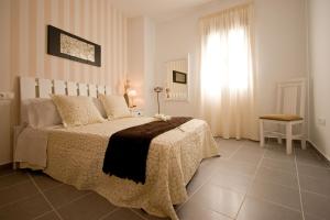 a bedroom with a large bed and a window at BeSlow Ayamonte in Ayamonte