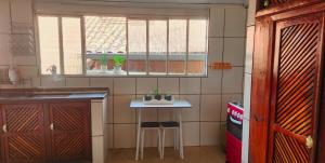 a small kitchen with a small table and a window at Casa Chico Rei in Ouro Preto
