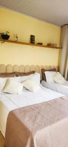 a bedroom with two beds and a yellow wall at Casa Chico Rei in Ouro Preto