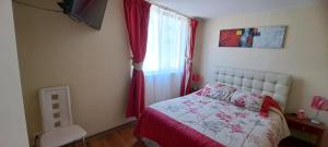ein Schlafzimmer mit einem Bett mit roten Vorhängen und einem Fenster in der Unterkunft Departamento a pasos del Faro in La Serena