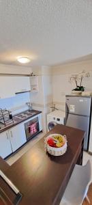 eine Küche mit einem Tisch mit einer Obstschale darauf in der Unterkunft Departamento a pasos del Faro in La Serena