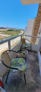 einen Balkon mit zwei Stühlen auf einem Gebäude in der Unterkunft Departamento a pasos del Faro in La Serena