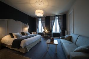 a hotel room with a bed and a couch at Chateau du Clos de la Ribaudiere - Teritoria in Chasseneuil-du-Poitou