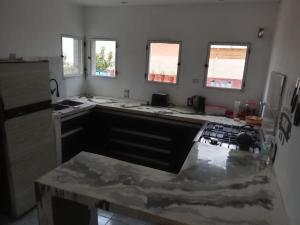 a kitchen with a counter top and some windows at La casa naranja de Amaia in Sierra Grande