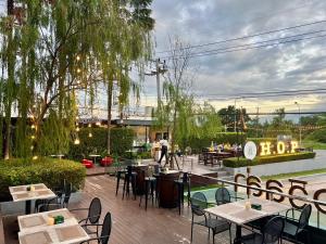 a restaurant with tables and chairs on a patio at Chaisaeng Villa in Sing Buri