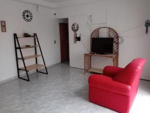 a living room with a red couch and a tv at La casa naranja de Amaia in Sierra Grande