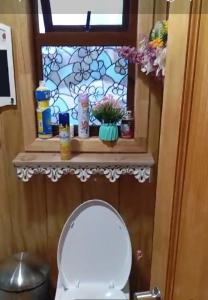 a bathroom with a toilet and a window at Patagon karim in Puerto Cahacabuco +1 photo