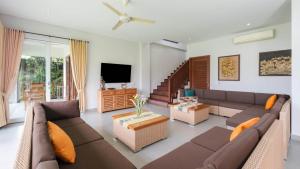 a living room with a couch and a tv at Villa Yenian by Villa Finder in Canggu