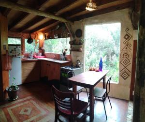 eine Küche mit Tisch und Stühlen und einem Fenster in der Unterkunft Casa Kawsay Punta N in Barra de Portezuelo