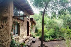 ein Haus mit einer Bank davor in der Unterkunft Casa Kawsay Punta N in Barra de Portezuelo