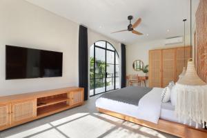a bedroom with a bed and a flat screen tv at Villa Sugi Umalas in Canggu +36 photos