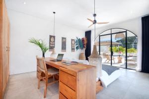 a home office with a wooden desk and chairs at Villa Sugi Umalas in Canggu