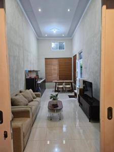 a living room with a couch and a table at Villa Hollandia in Kedungdang +2 photos