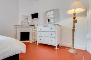 a bedroom with a white dresser and a lamp at Le Van Loo in Aix-en-Provence