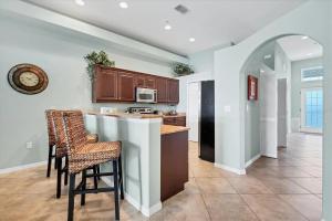 a kitchen with a bar with chairs and a counter top at Waterside Condo - Boca Grande & Manasota Beaches minutes away - January till the 28th is still Available! in Rotonda West
