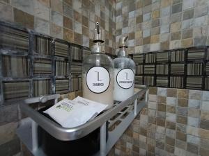 two bottles sitting on a shelf in a bathroom at Lagom Apart 1 in Posadas
